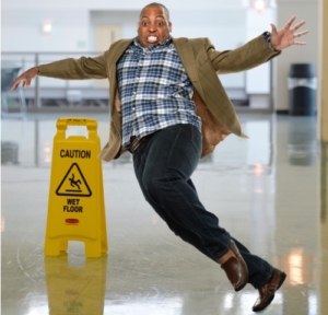 person slipping next to wet floor sign