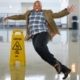 person slipping next to wet floor sign