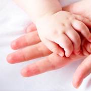 Baby's hand in adult's hand