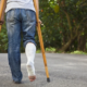 Person in crutches and leg cast walking away